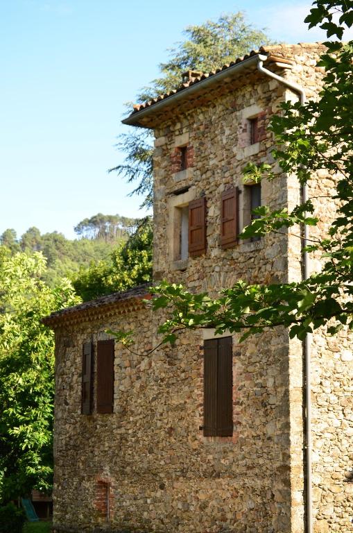 an old stone building with windows and trees at Mas Mialou in Saint-Jean-du-Gard