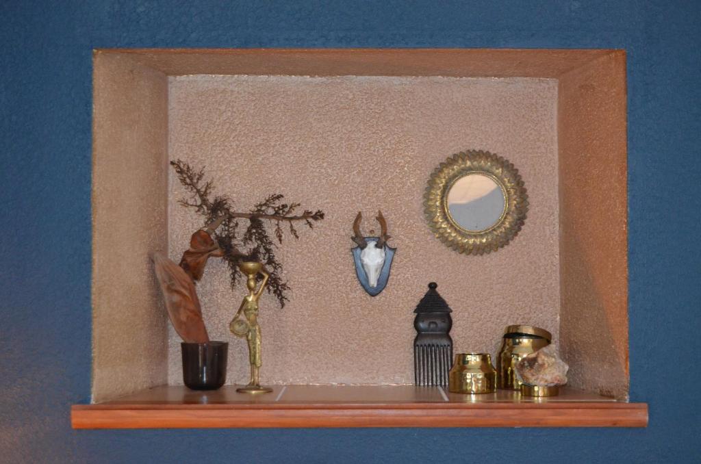 a shelf with a mirror and other items on it at Mas Mialou in Saint-Jean-du-Gard