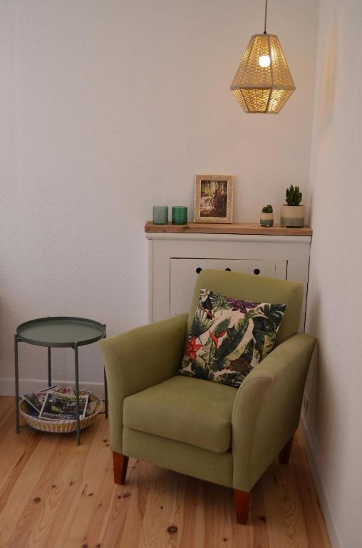 a green chair in a living room with a table at Mas Mialou in Saint-Jean-du-Gard