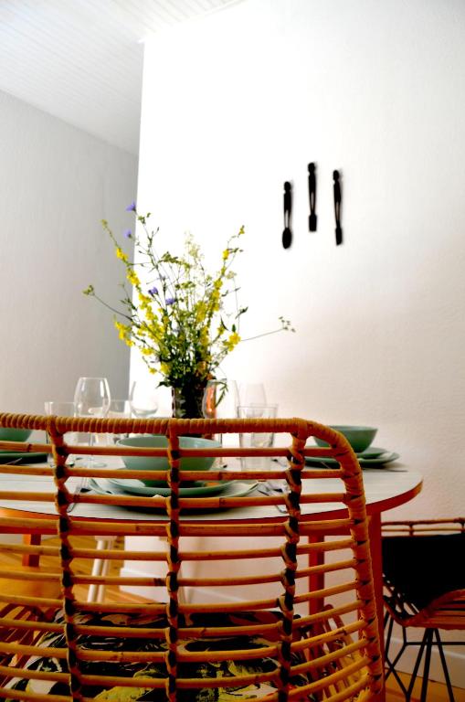 a dining room table with chairs and a vase of flowers at Mas Mialou in Saint-Jean-du-Gard