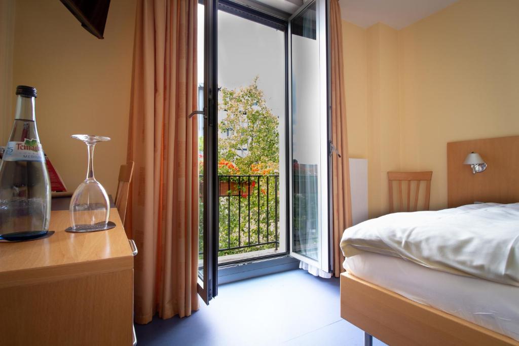 a bedroom with a bed and a window with a balcony at Hotel Goldene Gans in Mannheim