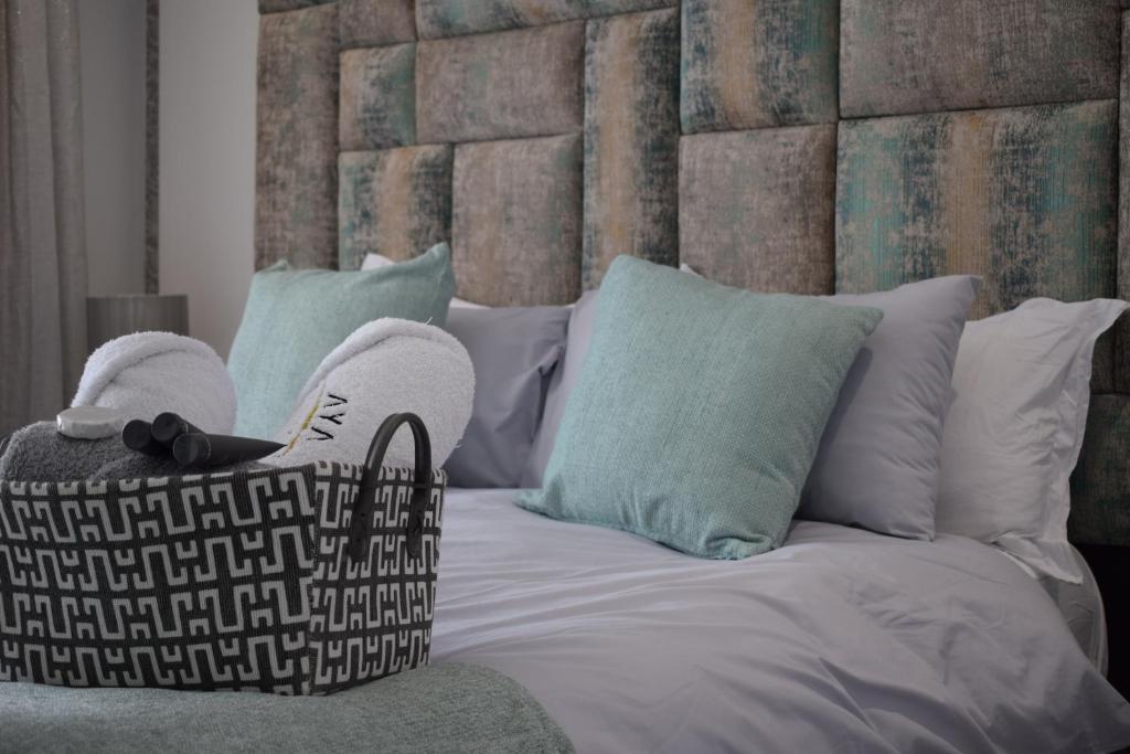 1 dormitorio con 1 cama con cabecero grande y almohadas en Aya Luxury Apartment 84, en Durban