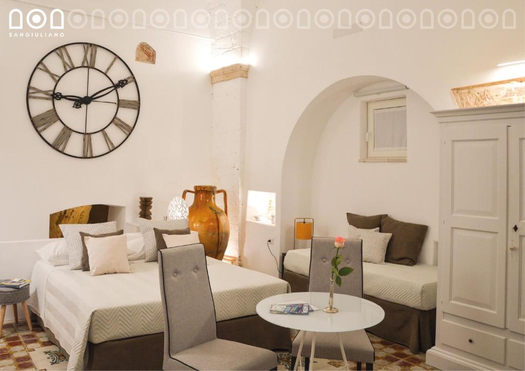 un soggiorno con divano e orologio sul muro di Sangiuliano a Laterza