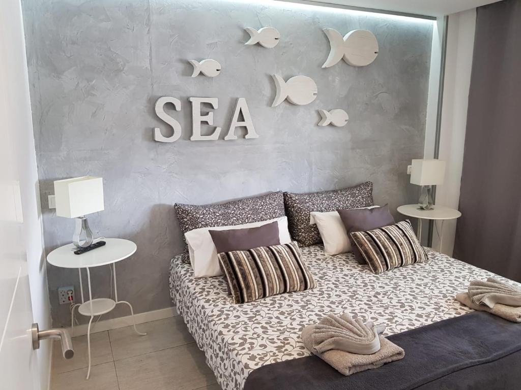 プラヤ・デル・イングレスにあるYumbo Movida Accommodationのベッドルーム1室(ベッド1台、壁に海の看板付)