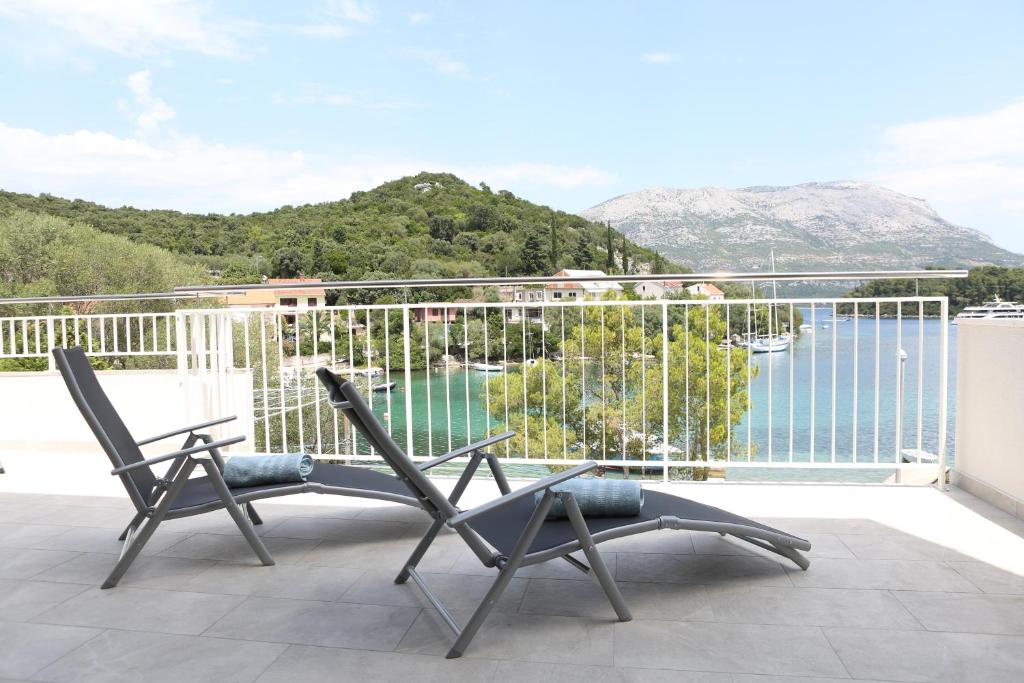 a balcony with two chairs and a view of the water at Sea Breeze Gugic in Korčula