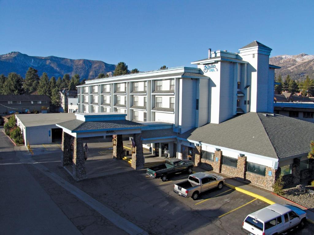 a large white building with cars parked in a parking lot at Shilo Inn Mammoth Lakes in Mammoth Lakes