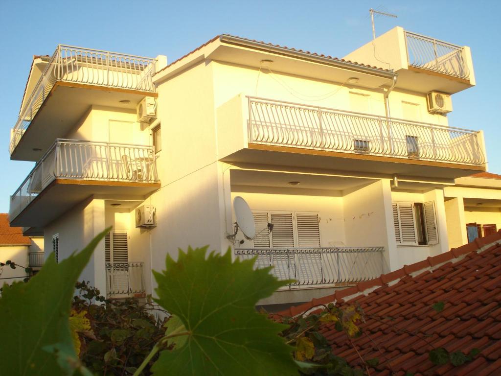 un edificio blanco con 2 balcones y techo rojo en Apartments Nikolas, en Vodice