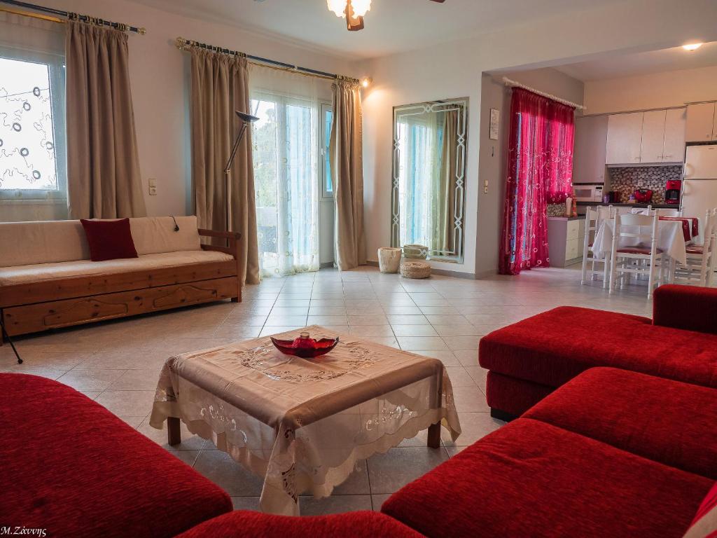 a living room with red couches and a table at Xenia Apartment in Kokkari