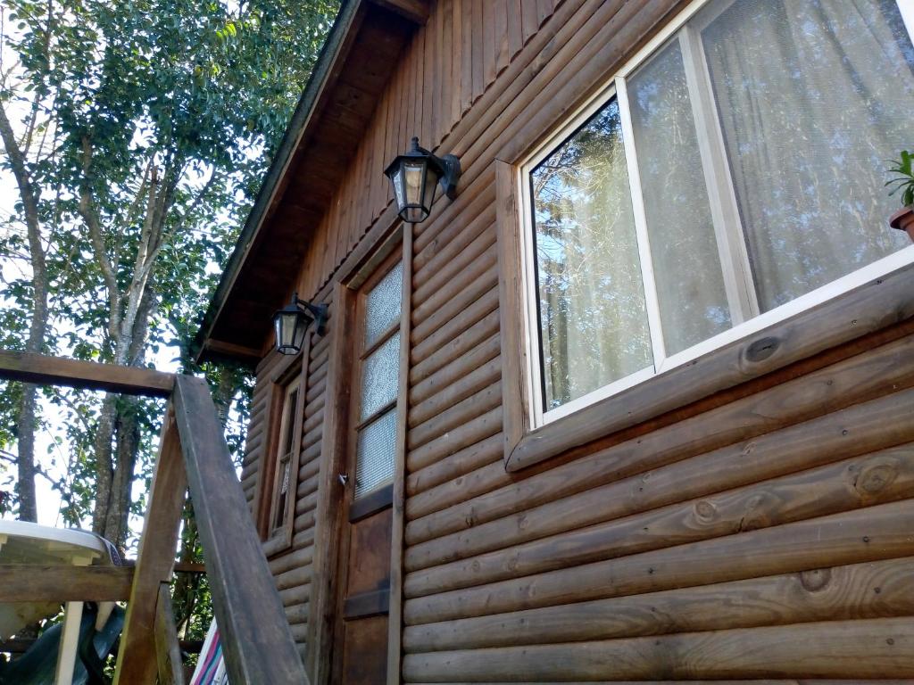 una cabaña de madera con una ventana en el lateral. en Cabaña mandala en Tigre