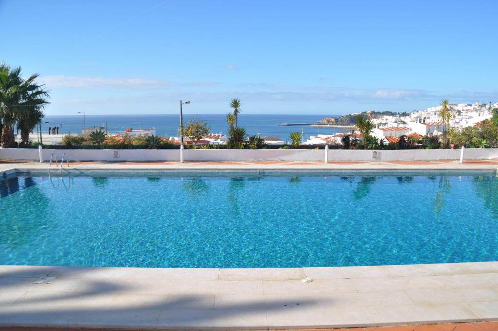 a swimming pool with a view of the ocean at Almar Hotel Apartamento in Albufeira
