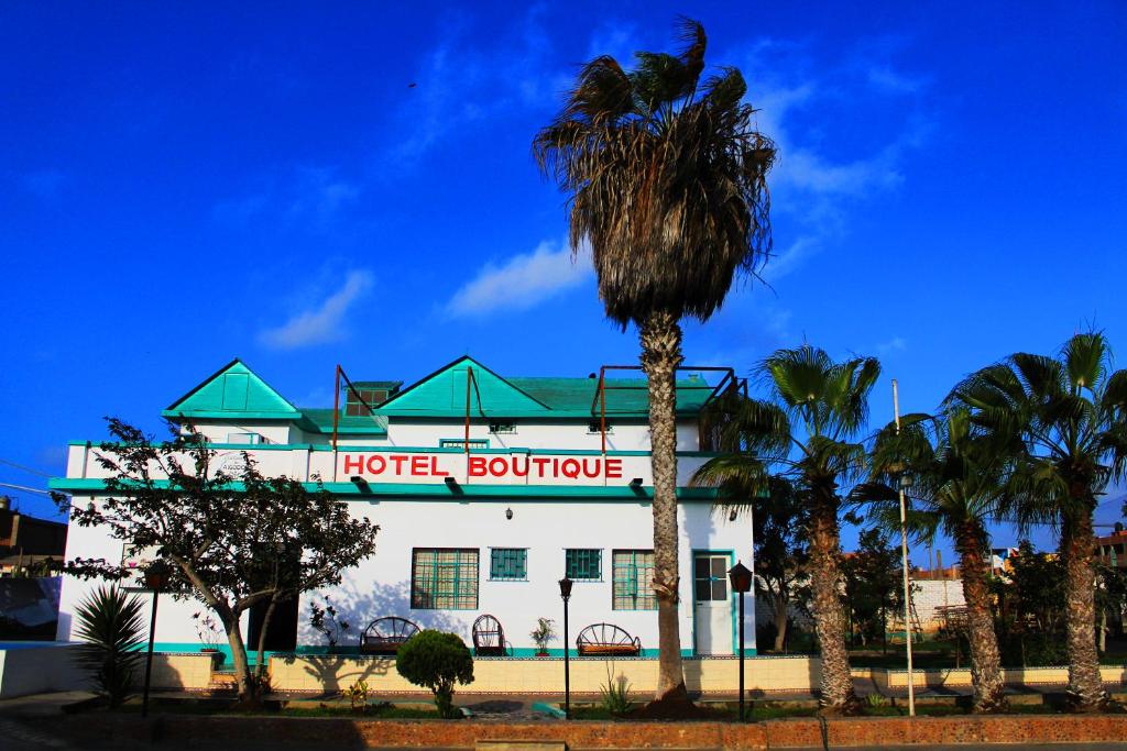 un edificio de hotel con una palmera delante en La Casa de Algodon, en Huacho