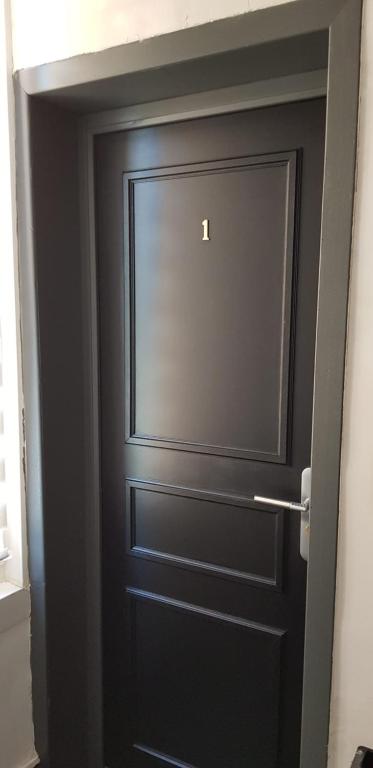a black door in a room with at Val&#39; Appart 1 in Valenciennes