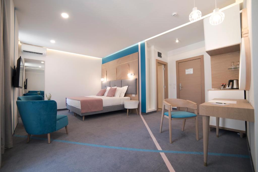 um quarto de hotel com uma cama, uma mesa e cadeiras em City Nest Modern & Cozy Suites em Belgrado