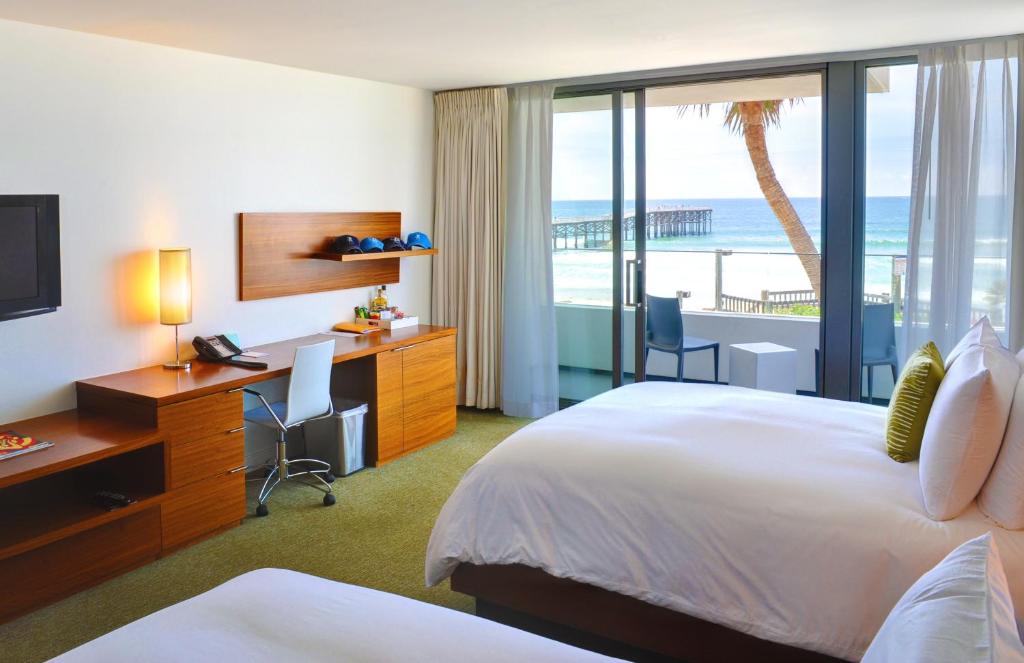 a hotel room with a bed and a desk with a computer at Tower 23 Hotel in San Diego