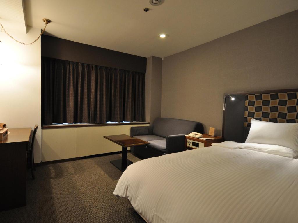 Postel nebo postele na pokoji v ubytování Mito Keisei Hotel