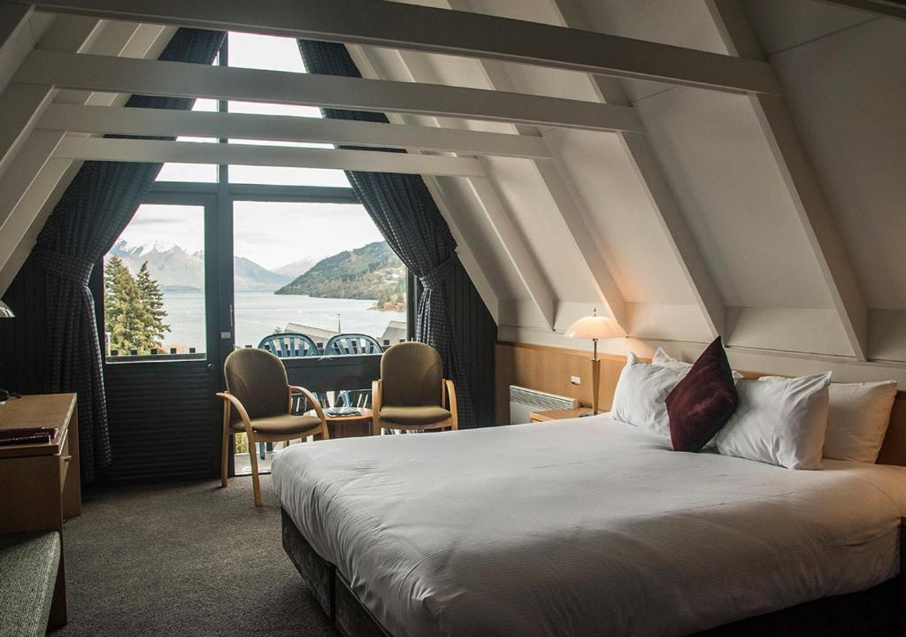 a hotel room with a bed and a large window at Heartland Hotel Queenstown in Queenstown