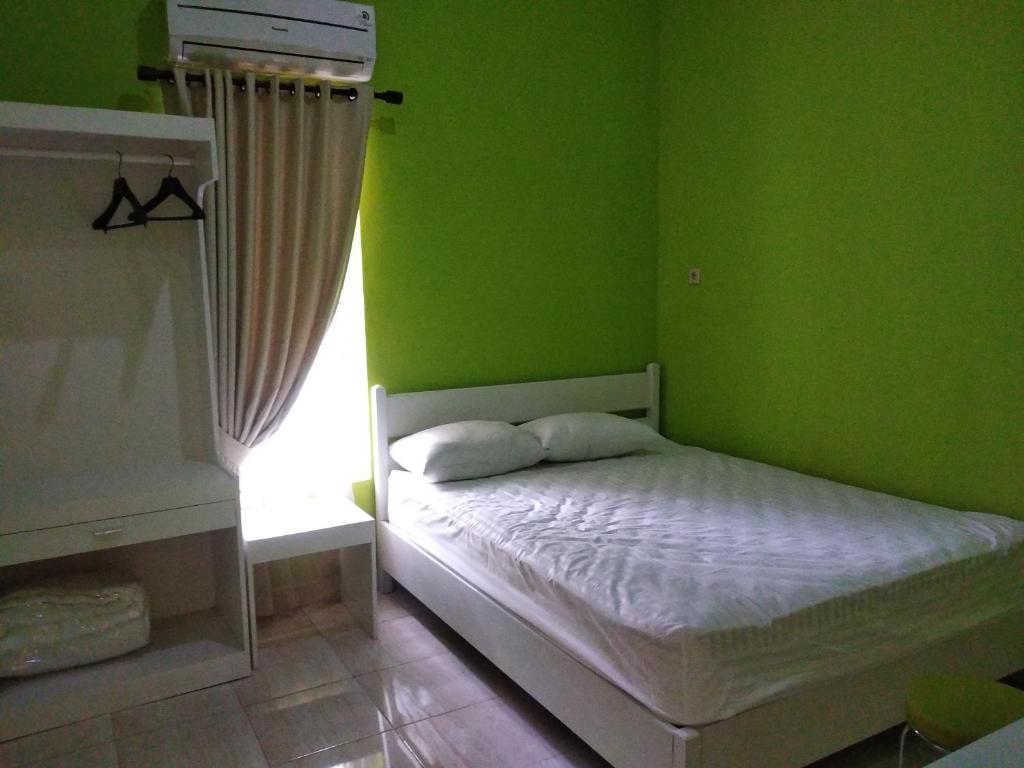 Postel nebo postele na pokoji v ubytování Omah Inap D24 Syariah near Universitas Aisyiah Yogyakarta Mitra RedDoorz