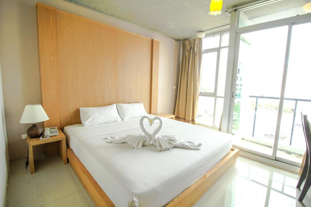 een kamer met een bed met een zwanendecoratie erop bij Bansabai Sabaidee Service Apartment in Bangkok
