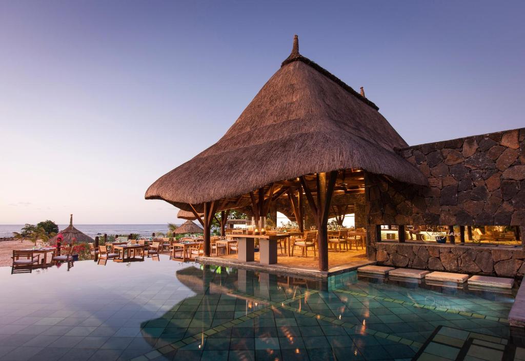 a resort with a pool with tables and chairs at Veranda Pointe Aux Biches Hotel & Spa in Trou aux Biches