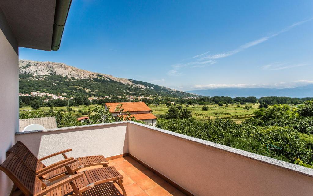 a balcony with chairs and a view of a mountain at Apartman Maledi in Baška