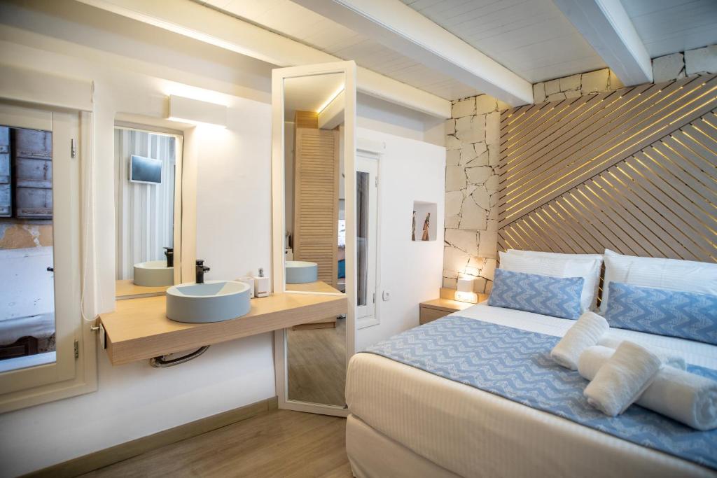 a bedroom with a bed and a bathroom with a sink at Nine - Cozy Rooms in Chania
