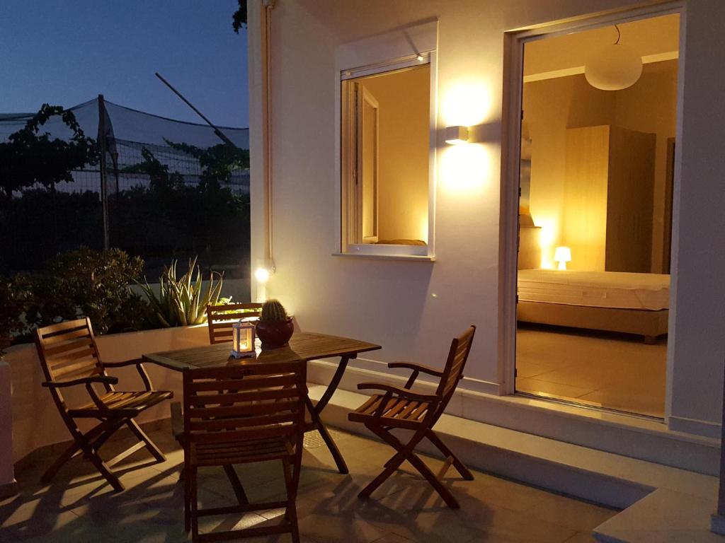 d'une terrasse avec une table, des chaises et une fenêtre. dans l'établissement Minimalistic Apartment Near the Sea, à Gouves