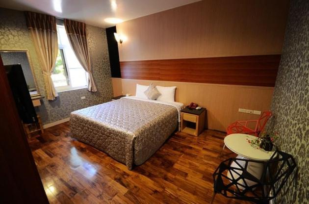 a hotel room with a bed and a table at Xi Xin Guan Hot Spring Resort in Baihe