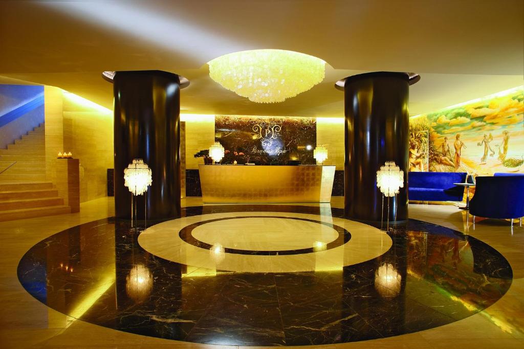 a lobby with a large glass table and a chandelier at Grand Hotel Bernardin in Portorož