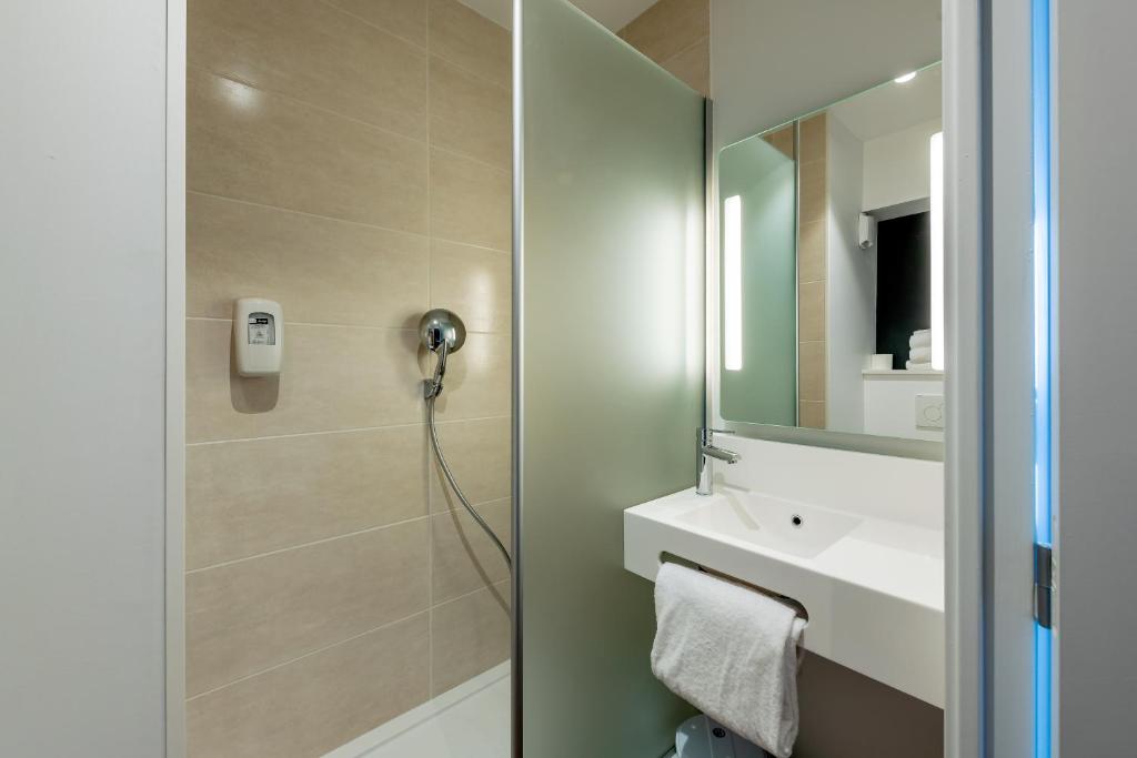 La salle de bains est pourvue d'une douche, d'un lavabo et d'un miroir. dans l'établissement B&B HOTEL Bordeaux Centre Gare Saint-Jean, à Bordeaux