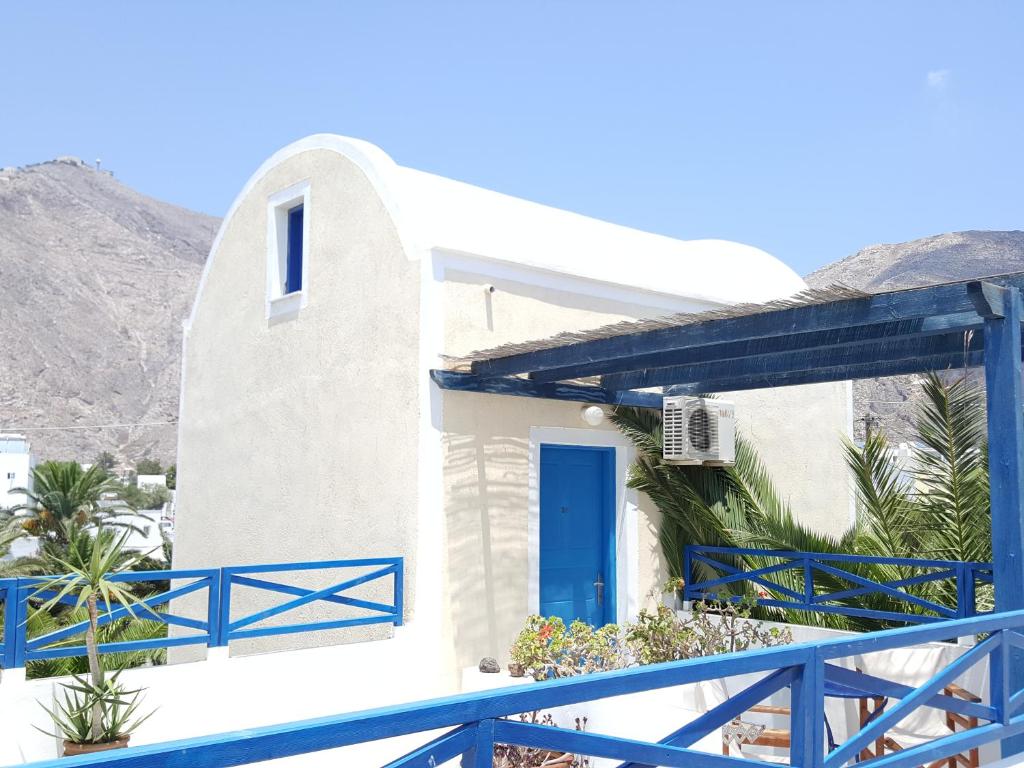 a house with a blue fence and a blue door at Villa Spyros Santorini in Perissa