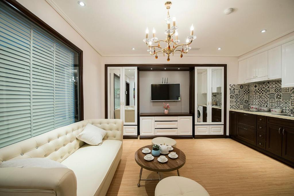 uma sala de estar com um sofá branco e uma mesa em Hong Gia Tue Apartment em Hanói