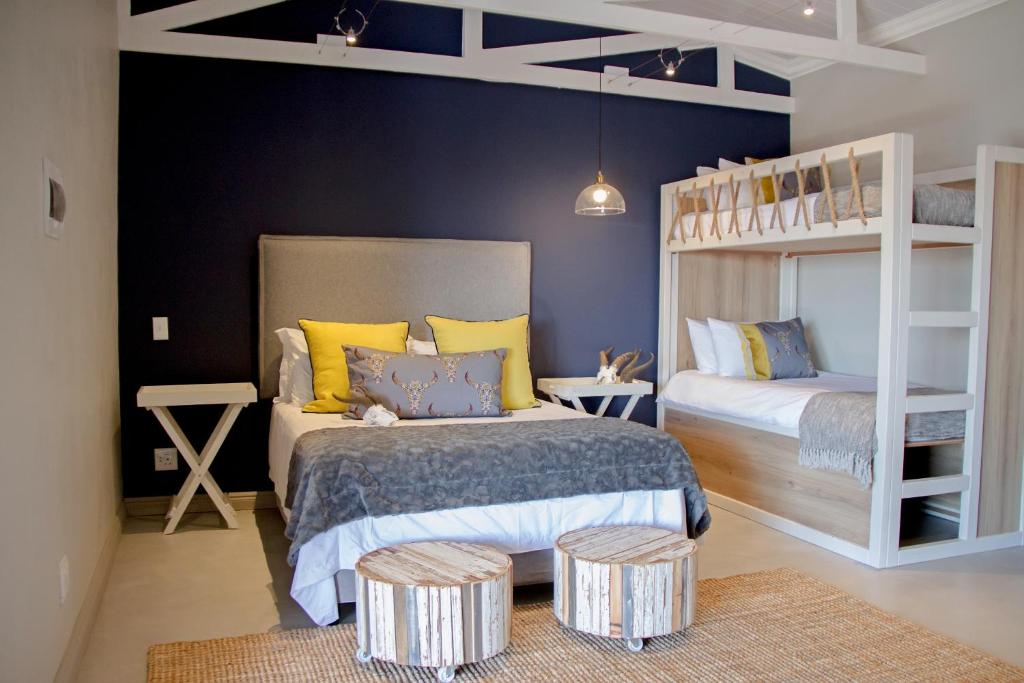 a bedroom with two bunk beds and two tables at Figberry Guestrooms in Bloemfontein