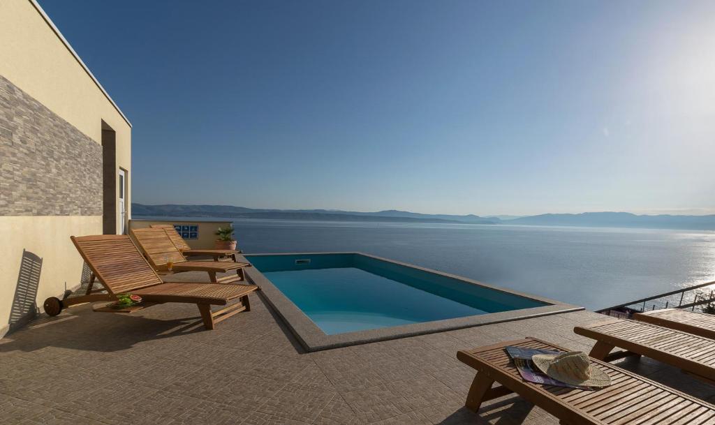 a swimming pool on a patio with a view of the water at Vila Vita in Donje Selo na Šolti
