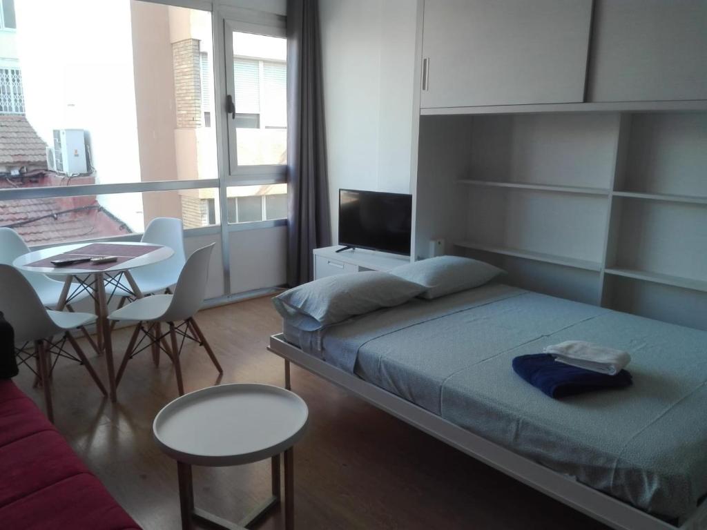 アリカンテにあるCalle Manero Mollá, 16, 6-3の小さなベッドルーム(ベッド1台、テーブル、ソファ付)