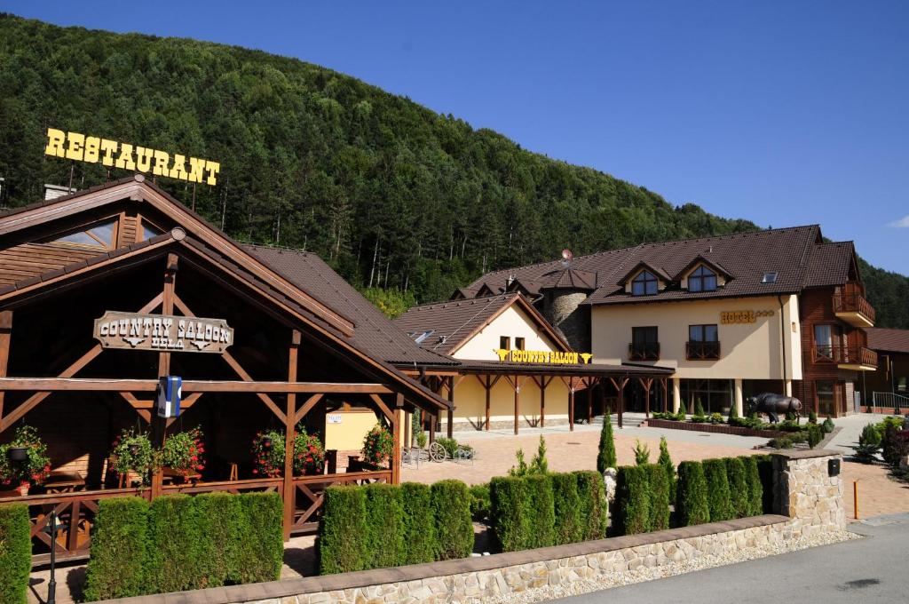 a building with a sign in front of a mountain at Country Saloon Belá in Svit