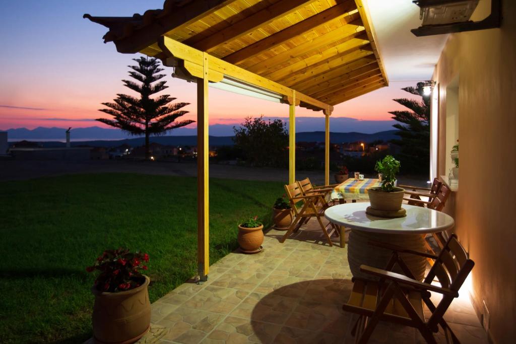 a patio with a table and chairs and a sunset at Laconia Domus - Papadianika in Pappadhiánika