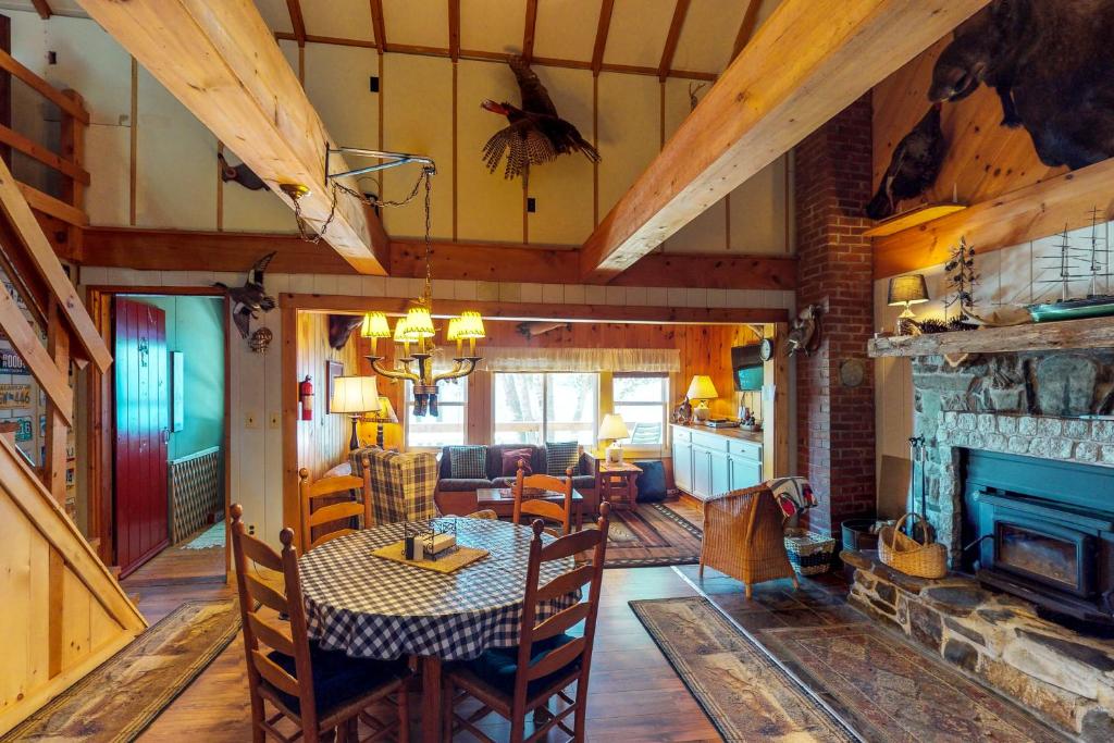 uma sala de jantar e sala de estar com uma mesa e uma lareira em Pebble Cove em The Highlands