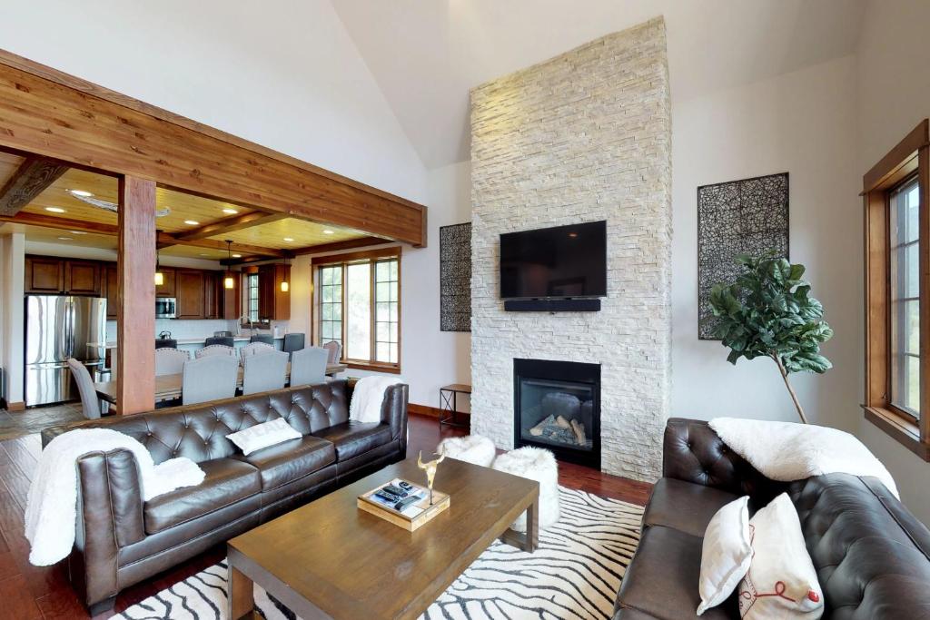 Una sala de estar con un sofá y una chimenea. en Moose Hill 59, en Big Sky