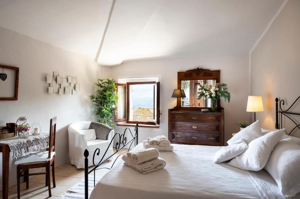 - une chambre avec un grand lit et des serviettes dans l'établissement La Casa di Gelda, à Montalcino
