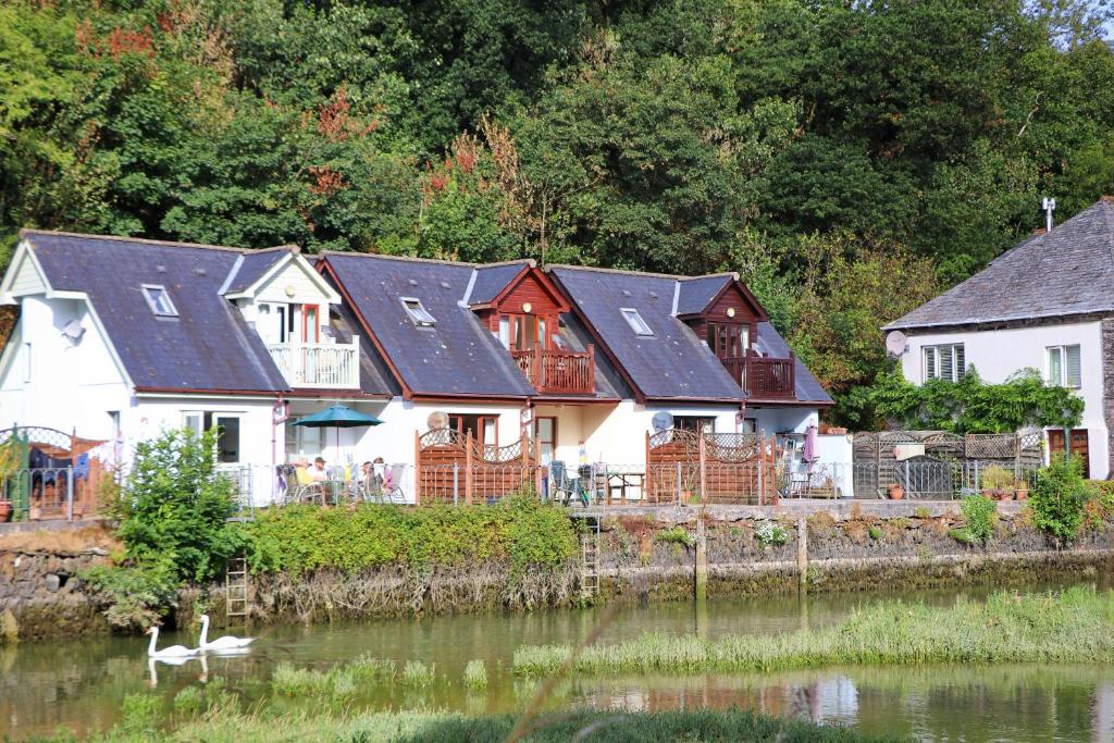 eine Reihe von Häusern neben einem Wasserkörper in der Unterkunft WATERSIDE cottage in Wadebridge