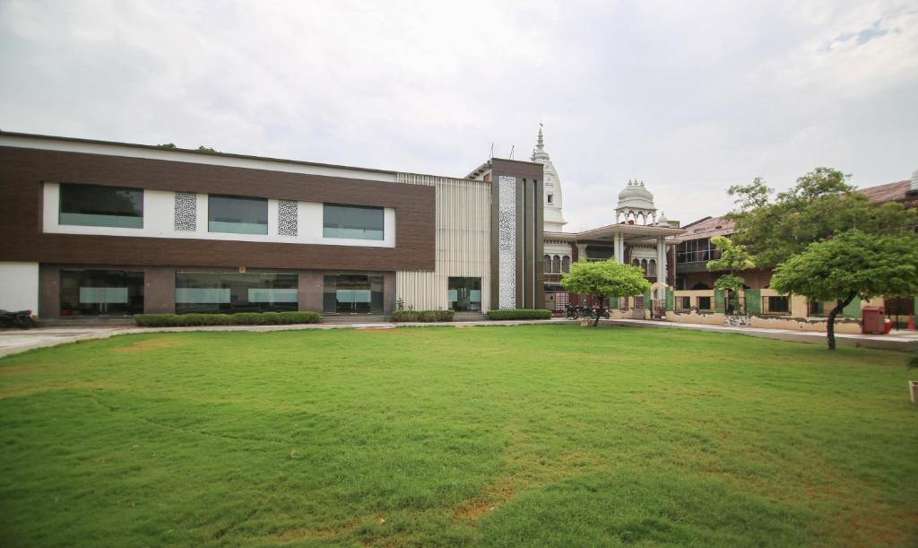 a large grass field in front of a building at Yashogopal Resortico in Vrindāvan