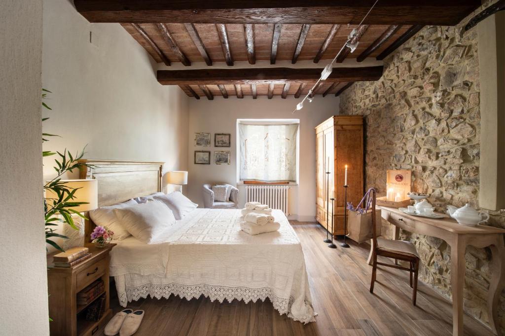 um quarto com uma cama grande e uma parede de pedra em La Casetta di Brunello em Montalcino
