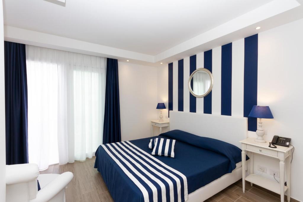 a blue and white bedroom with a bed and a mirror at Hotel Nautilus in Cagliari