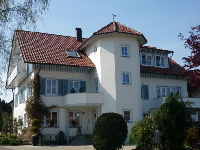 une grande maison blanche avec un toit rouge dans l'établissement Haus Schnitzler, à Wasserburg