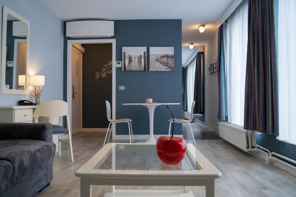 فندق فيرست يوروفلات في بروكسل: غرفة معيشة مع طاولة وتفاح احمر عليها