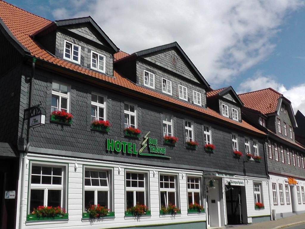 un grand bâtiment noir et blanc avec des fleurs dans les fenêtres dans l'établissement Hotel Die Tanne, à Goslar