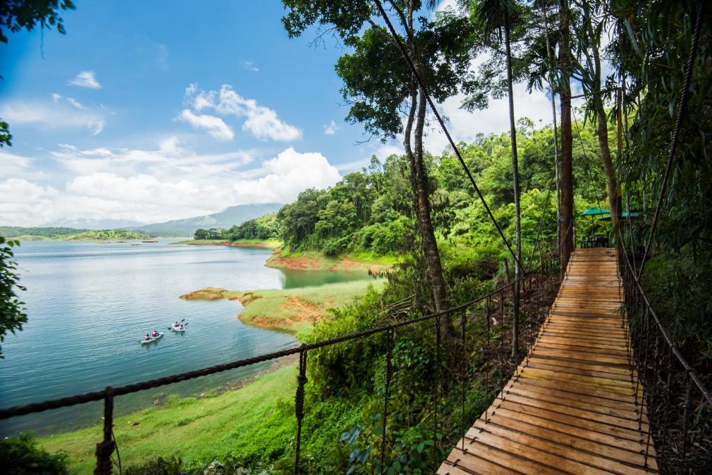 un puente colgante sobre un río con barcos en el agua en The Serenity Resort en Tariyod