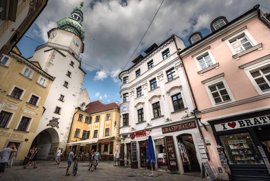 a city street with buildings and a clock tower at Apart-Hostel ZERO in Bratislava
