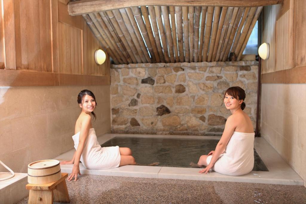 two women are sitting in a bath tub at OkutsuHotSpa IkedayaKajikaen in Kagamino