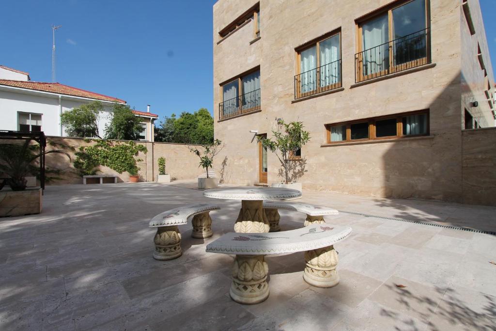 a stone table in front of a building at Apartamentos Villablino Arturo Soria in Madrid